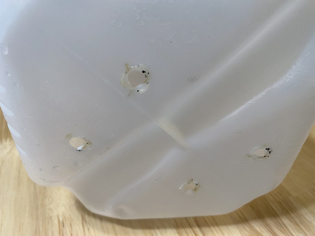 Holes poked in bottom of jug.  