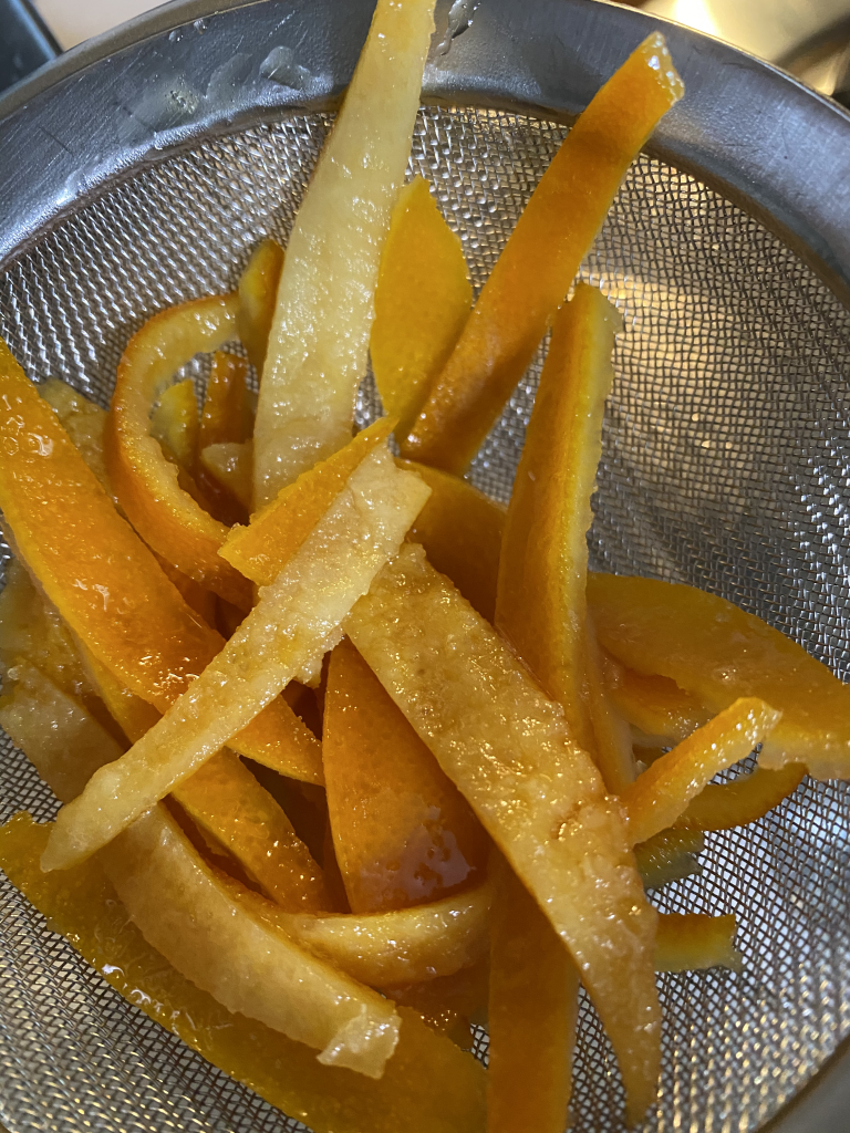 Honey-Candied orange peel after straining from the honey syrup.  They are mostly translucent and very soft. 