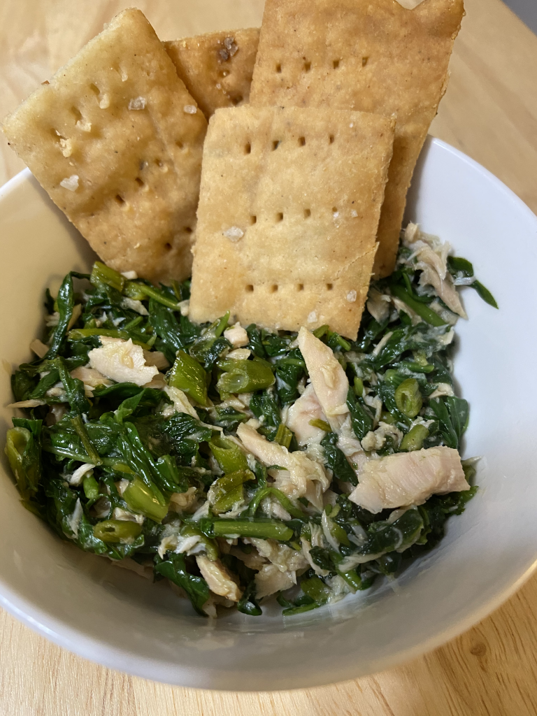 Cooked water spinach tuna salad served with gluten-free sourdough crackers