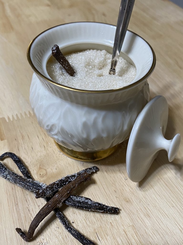 Vanilla sugar in sugar bowl, with dried vanilla beans from the vanilla sugar jar. 