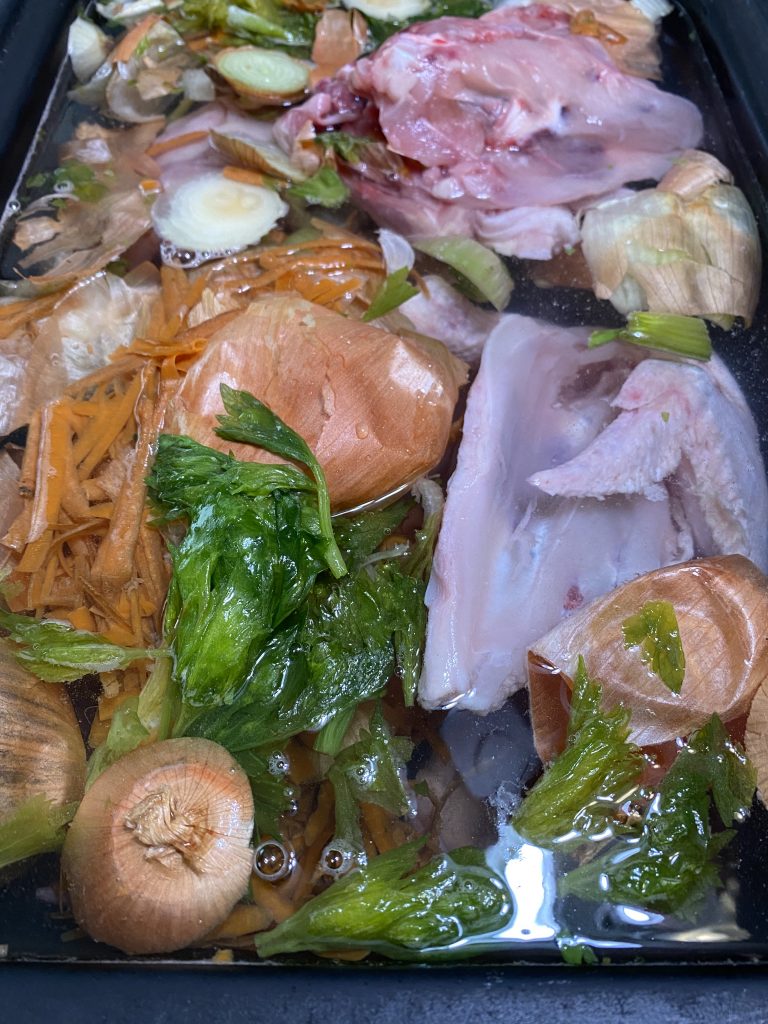 Roaster filled with chicken carcasses, vegetable scraps, water with a bit of unrefined sea salt, and vinegar.  Ready to turn on and simmer for 24 or more hours.
