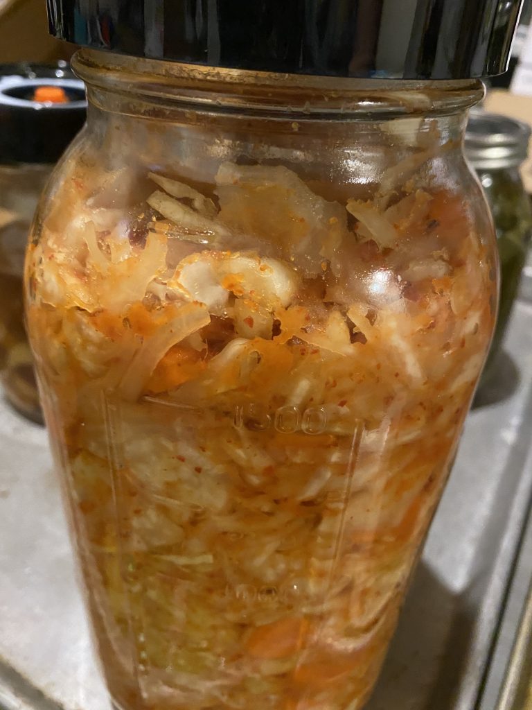 Jar of kimchi at the end of its fermentation cycle.  It has absorbed a lot of the liquid brine that was in the jar to begin the fermentation. 